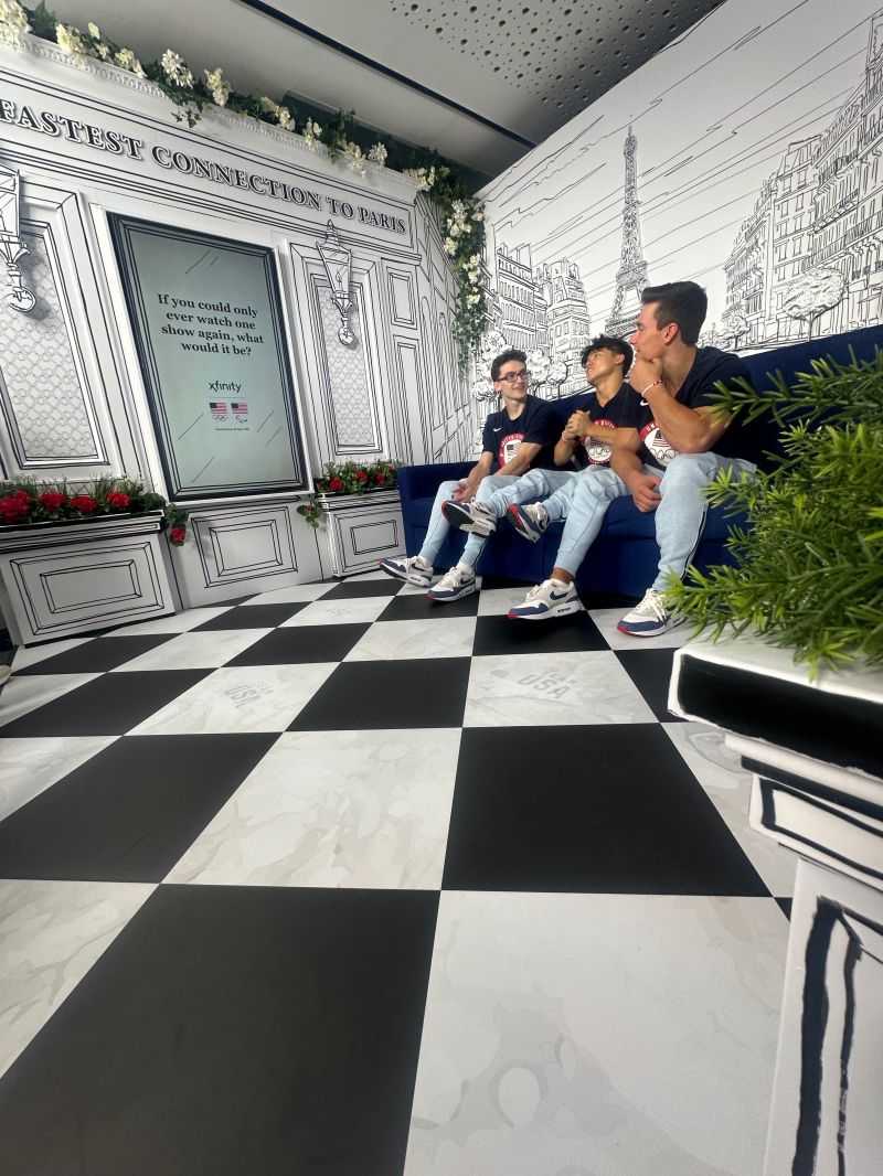 Low angle image of three Team USA athletes talking on the Xfinity couch.