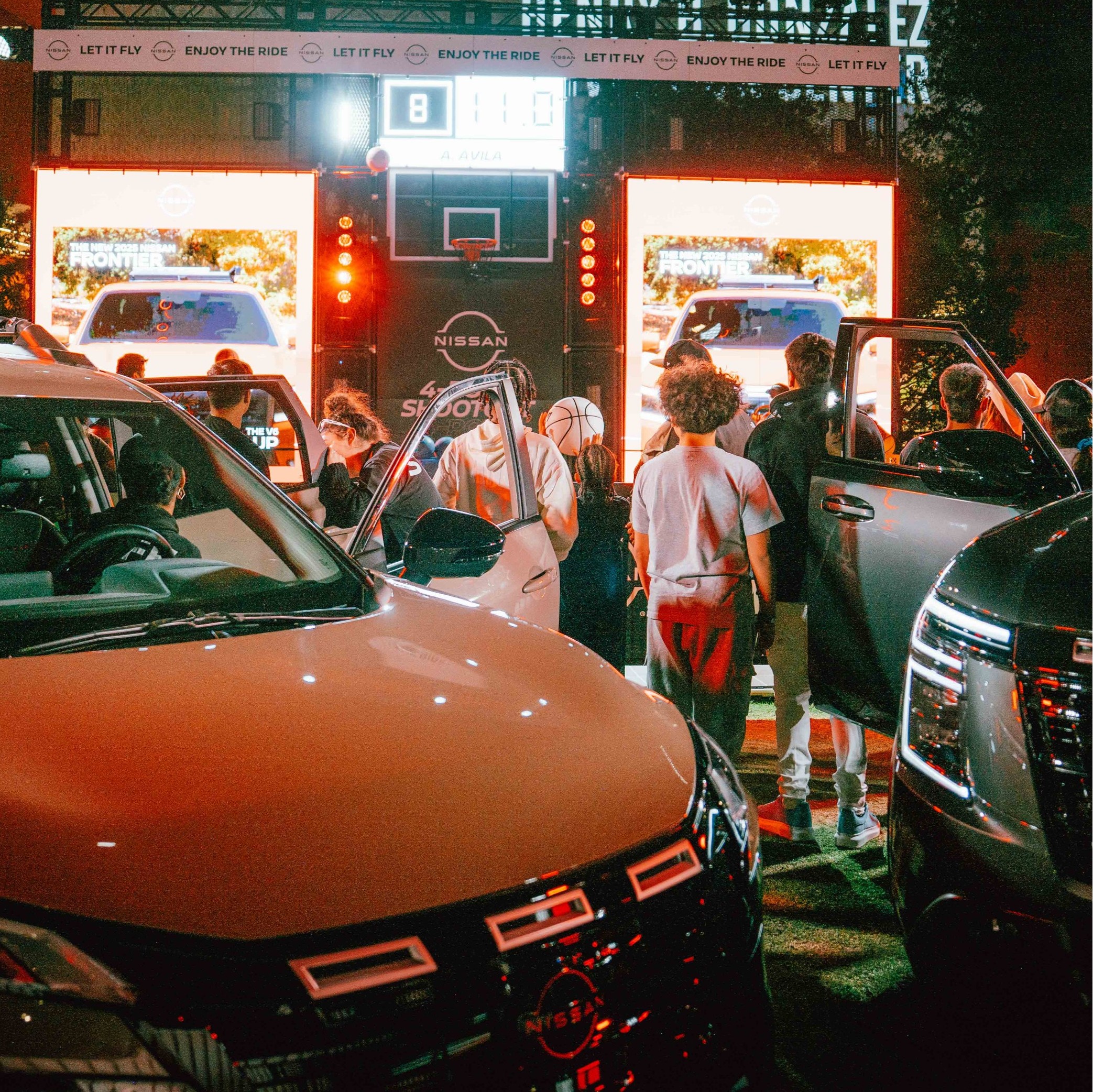 Night shot of patrons viewing the Nissan Car showcase.