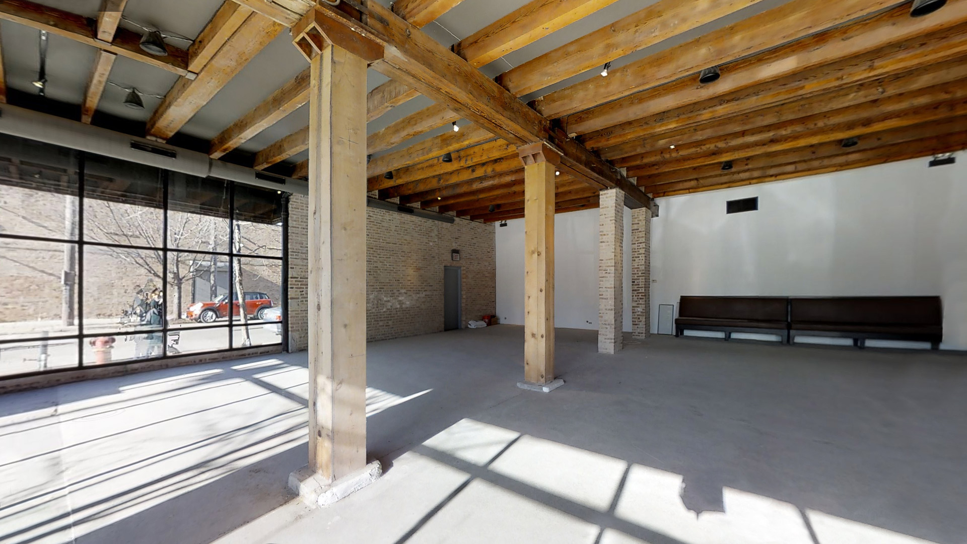 Former restaurant with exposed pillars and a glass window garage door